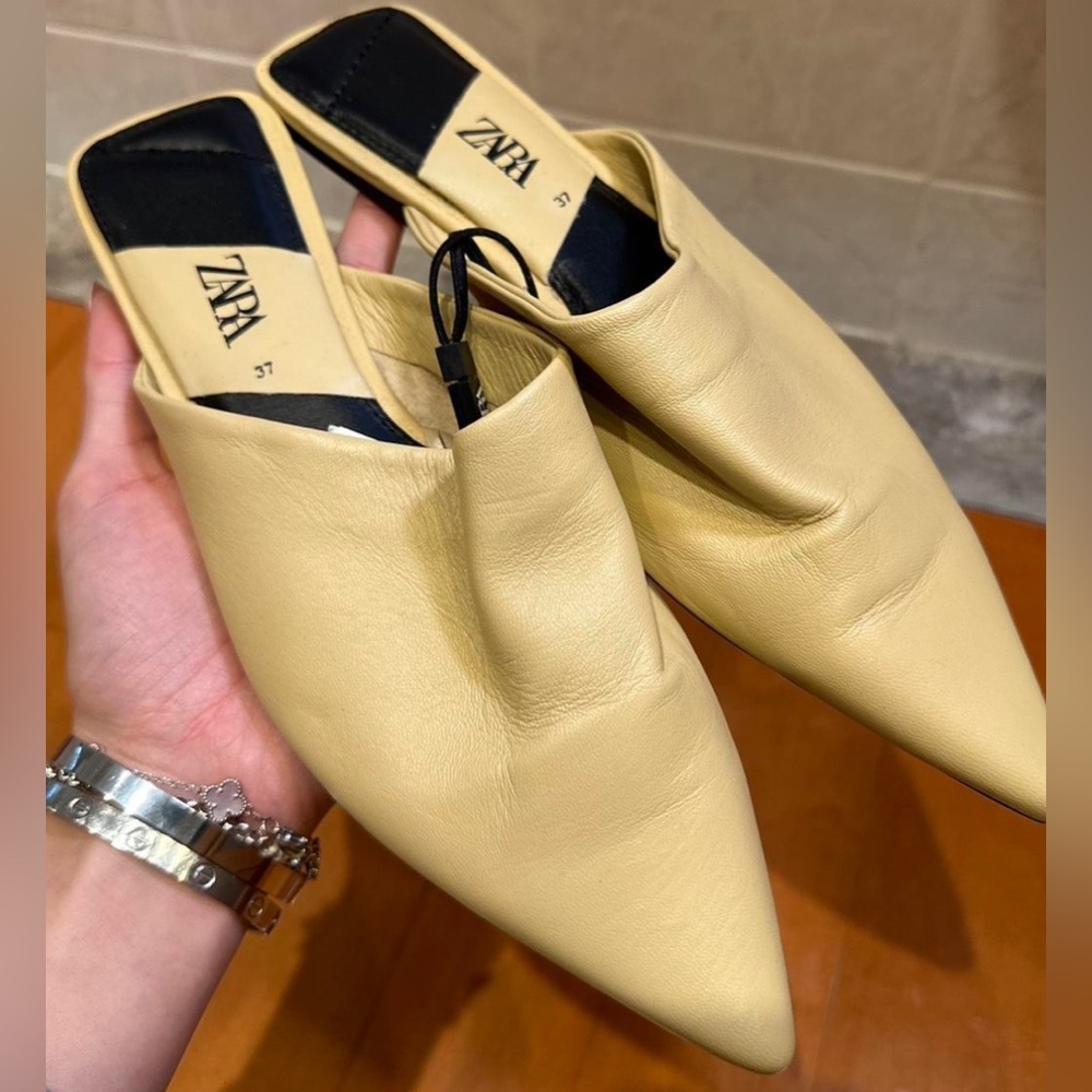 The cutest cream pointed toe leather slides.